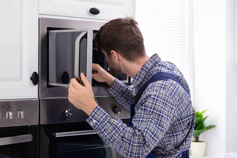 Man Repairing Microwave Oven